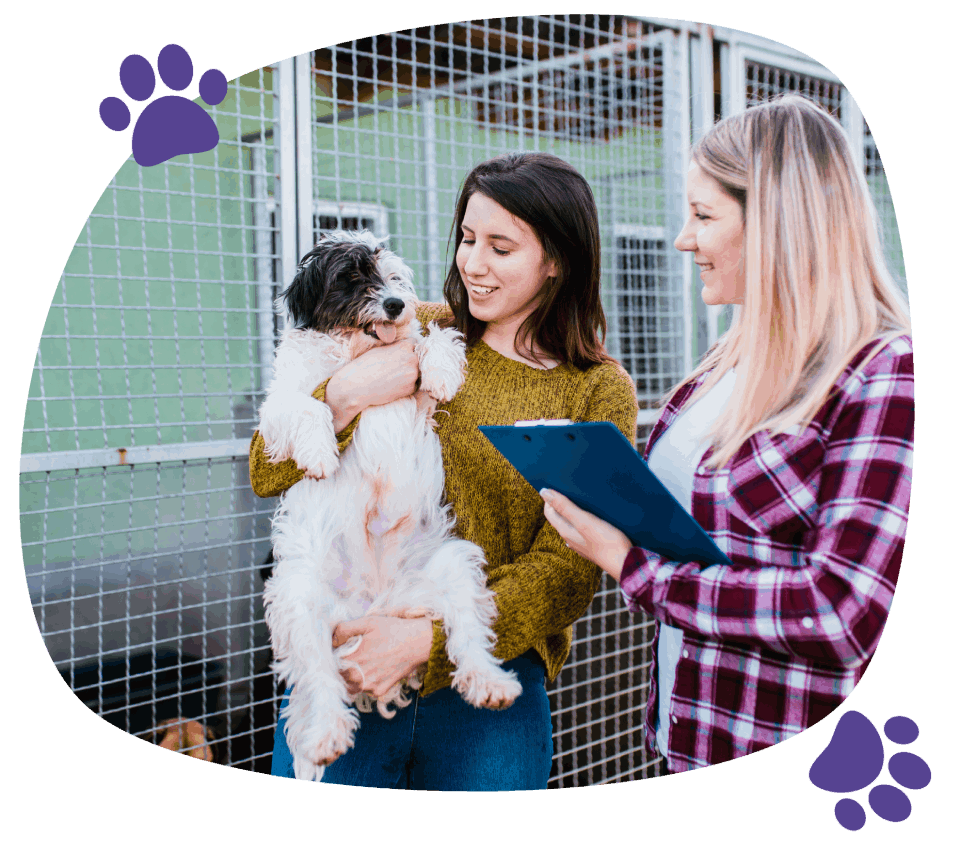 2 girls holding a dog while being happy