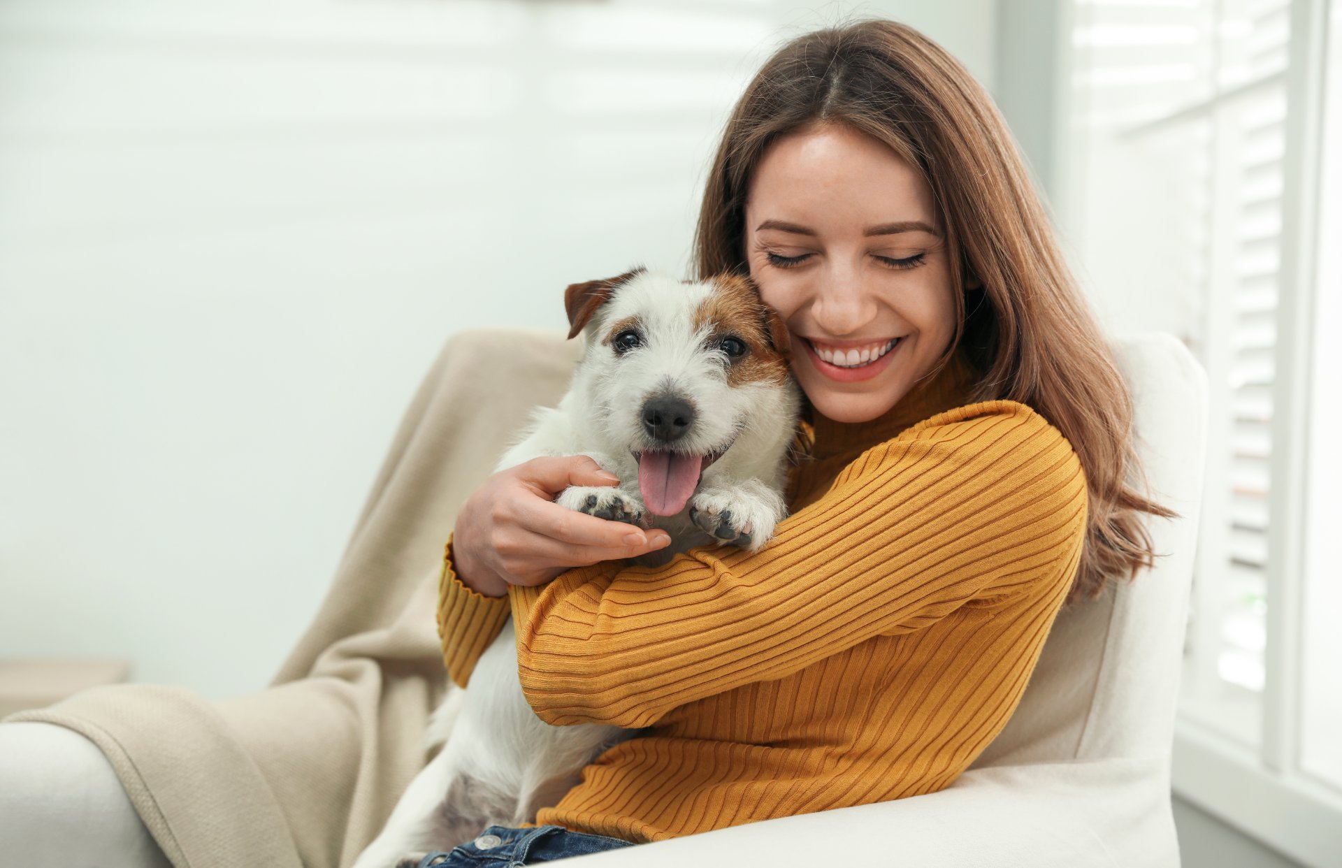 Woman holding puppy dog while being happy